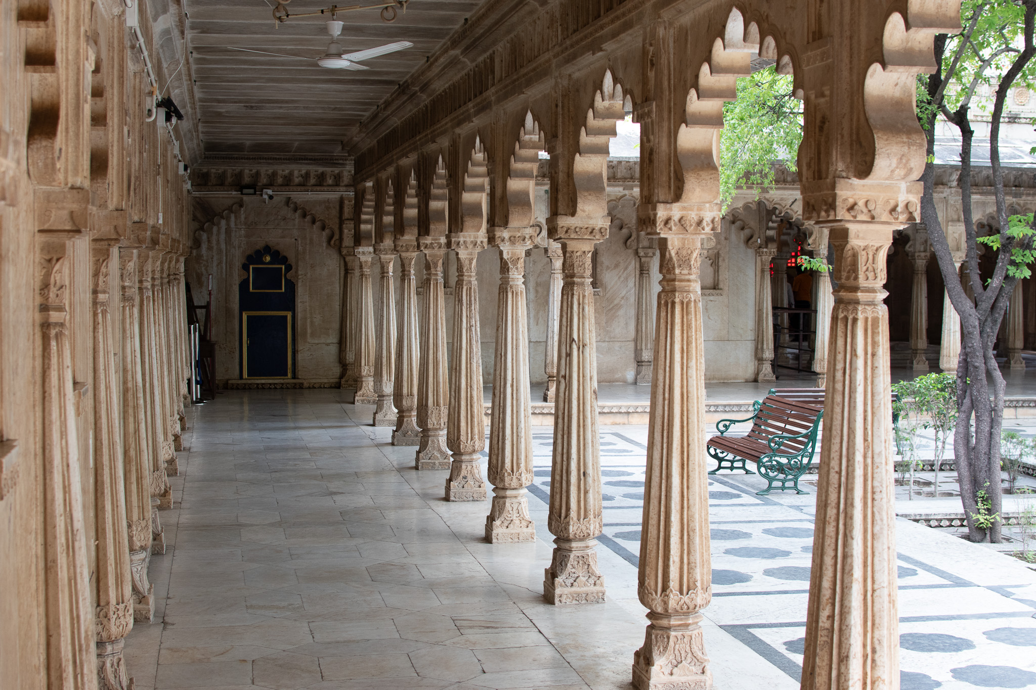 City Palace Udaipur corridor with repeating arches and strong leading lines.