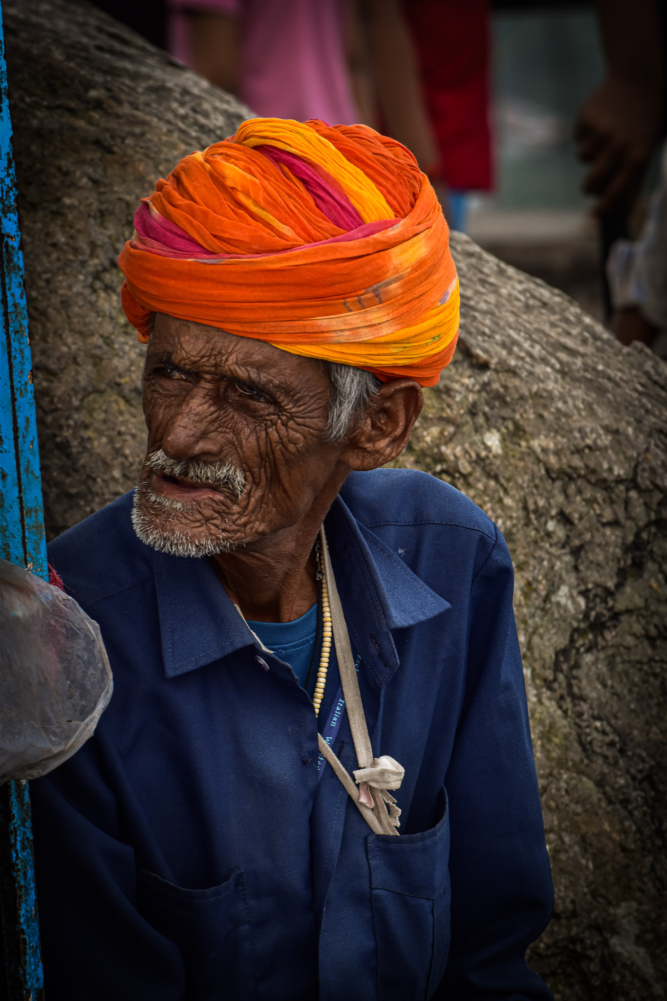 Street vendor portrait with a quiet expression, photographed in available light.